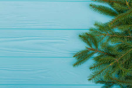 Green spruce branches with text space. Fir twigs for Christmas on blue wooden background. Christmas...