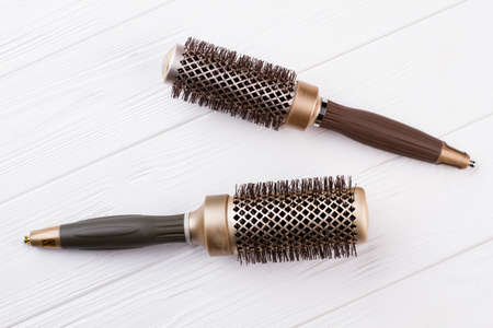 Two round hair brushes on wooden background. Professional hair brushes for salon.