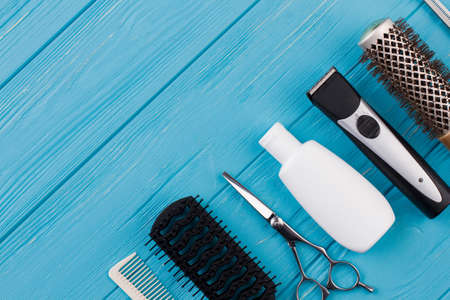 Barber shop equipment on blue wooden background. Professional hairdressing tools on table. Space for...