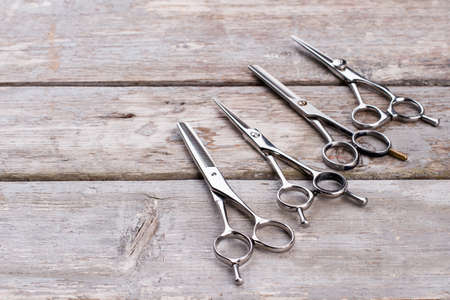 Stylish hairdresser tools on wooden background. Professional hairdresser scissors set. Space for text.の写真素材