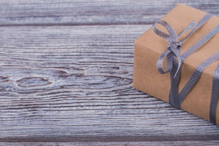 Brown gift box with gray ribbon. Gift box wrapped in kraft paper and tied with silver ribbon, copy...