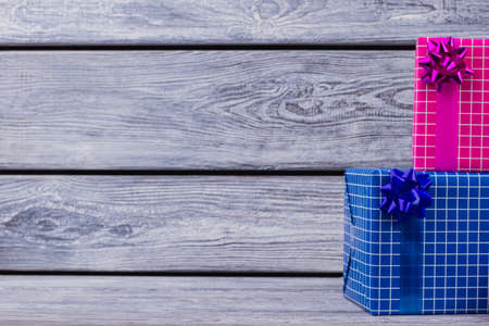 Christmas gift boxes and copy space. Present boxes wrapped in colored paper on wooden background....