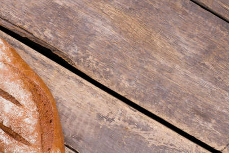 Bread on rustic wooden background. Loaf of bread and copy space.