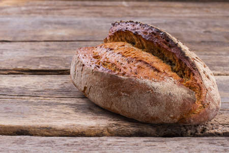 Loaf of natural bread on rustic background. Delicious fresh bread with seeds. Homemade rye bread...