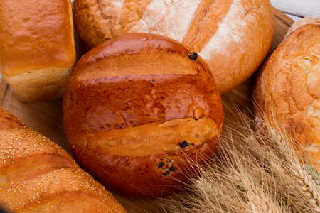 Various bakery products and wheat ears. Fresh baked bread with wheat ears.