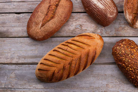 Artisan bread on rustic wooden background. Natural whole grain bread on wooden boards.の写真素材