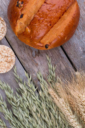 Fresh homemade bread and cereal ears. Fresh delicious bread and wheat ears on rustic wood table, top...