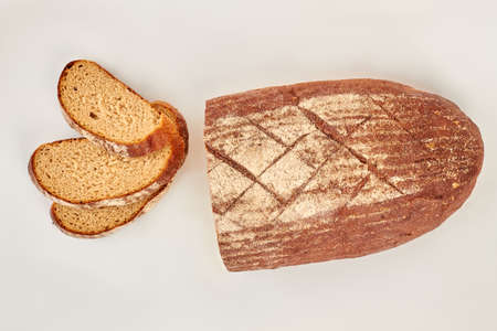 Loaf and slices of wheat bread on white background. Fresh cutted bread. Bakery, food concept.の写真素材