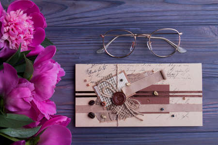 Presents for old woman. Glasses, vintage retro envelop with wax stamp and bouquet of flowers, top view, flat lay.の写真素材