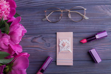 Gifts and accessories for mature woman, flat lay. Glasses, flowers, postcard, lipstic and mascara.の写真素材
