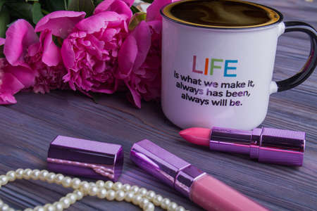 Peonies flowers, lipstic and cup of coffee. Close-up. Quote about life.の写真素材