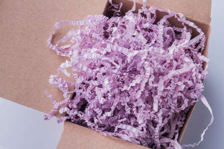 Pink shredded paper stuffing cardboard box. Top view, close-up.の写真素材
