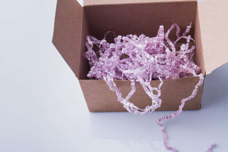 Box filled with shreddered purple paper. Isolated on white.の写真素材