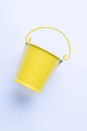 Side view yellow metal bucket isolated on a white background. Close-up. Enameled steel container.の写真素材