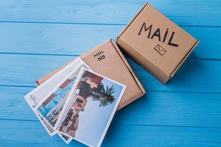 Sending photos via mail. Old vacation photos and carton cardboard mail boxes, flat lay, top view.の写真素材