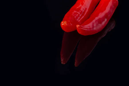 Red chili peppers on black background. Organic ingredient for cooking. Space for text.の写真素材