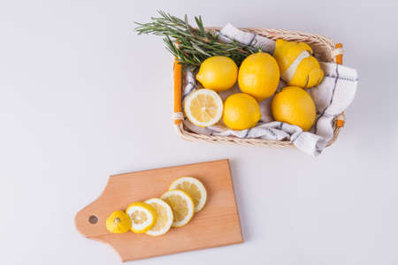 Lemons in a basket. Sliced lemon on cutting board. Food concept.