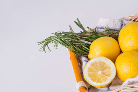 Lemons in basket with rosemary. Glossy citruses close up. Food concept.の写真素材