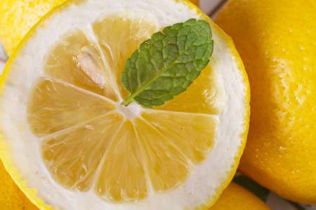 Lemon slice with mint leaf close up. Detail view of juicy lemon with mint. Vitamin C concept.