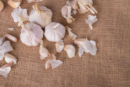 Organic garlic bulbs on burlap background. Garlic on vintage cloth. Natural healthy food concept.