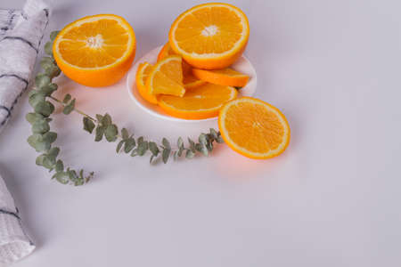 Sliced citrus fruit on white background. Fresh orange citrus fruit with leaves. Space for text.の写真素材