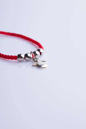Red necklace with silver angel and round beads. Isolated on white.の写真素材