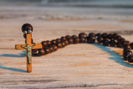 Sacred brown wooden rosary with jesus crucifix. Close-up, focused cross.の写真素材