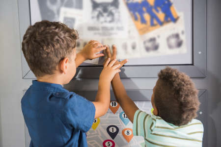 Kids playing cop and robber indoor. Fingerprinting to solve crime. Childrens role game in...