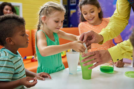 Kids doing chemical experiment at Birthday party. Colorful chemical reaction experiments for kids. Kids party entertainment ideas.の写真素材
