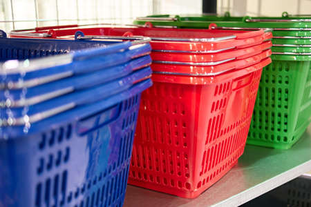 Stacks of empty shopping baskets. Blue red and green.