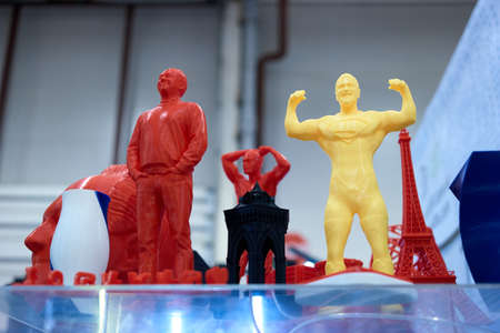 04.04.2019 - Kyiv, Ukraine. Strong men and towers printed on a 3d printer. Plastic red and yellow men figures.のeditorial素材