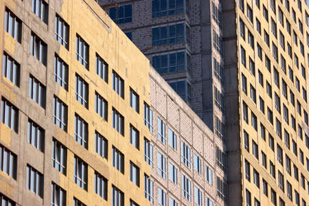 Close up facades of unfinished high rise buildings. Skyscrapers construction.