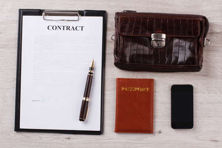 Contract with pen. Purse, passport and cellphone. Successful deal. Personal items.の写真素材