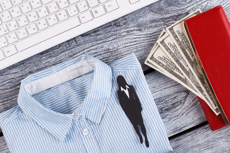 Businesswomans objects. Light shirt, scarlet wallet and keyboard. Paper figure of woman in suit.の写真素材