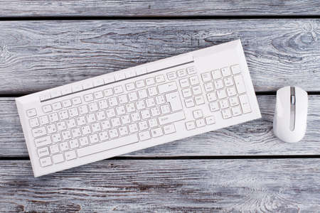 Keyboard and optical mouse top view. Computer objects on wooden surface. Minimalism concept.