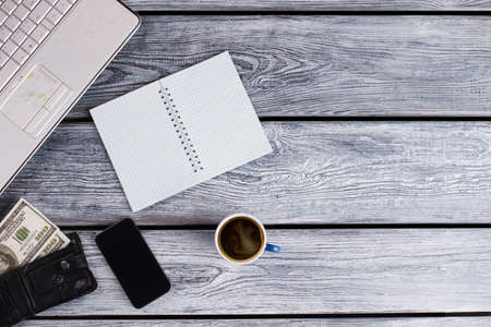 Laptop, planner, black purse and coffee. Mans flatlay on wooden surface.