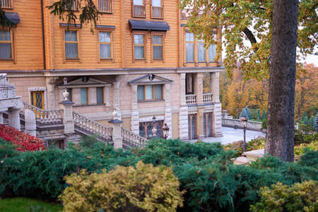Luxury house in autumn forest. Juniper bushes.