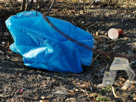 Blue plastic garbage bag on the ground. Close up. Enviroment pollution.