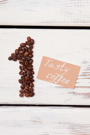The tastiest coffee concept. Coffee beans in a shape of number one and papaer with tasty coffee...