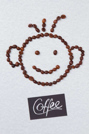 Coffee beans arranged in a shape of smiling boy. Isolated on white background. Vertical image.の写真素材