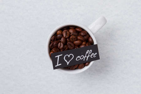 I love coffee concept. Flat lay cup full of roasted coffee beans isoated on white.の写真素材
