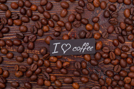 I love coffee concept flat lay. Scattered coffee beans on wood.