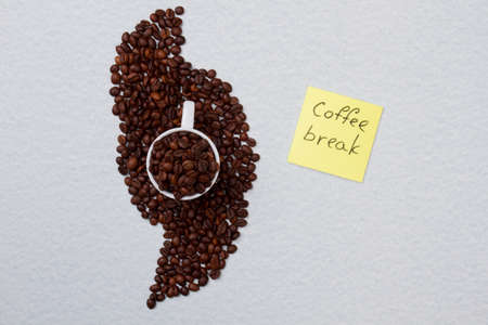 Coffee beans neatly arraned aroung cup. Coffee break concept. Isolated on white background.の写真素材