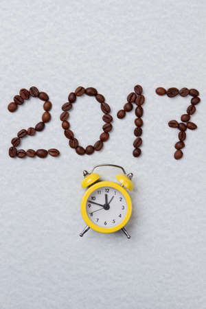 Coffee beans in a shape of 2017 number and alarm clock. Isolated on white background.の写真素材