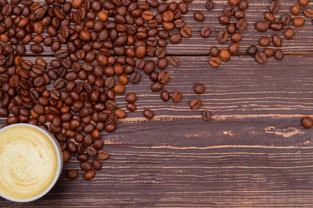 Cup of coffee with foam on wood and free space for text. Brown wooden surface on background.の写真素材