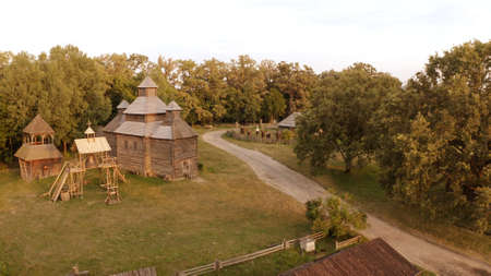 Wooden church and bell near the rural road. Meadow surrounds them.の写真素材