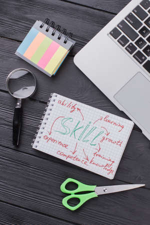 Clerical items on dark wood flat lay. Skills and self-development concept.