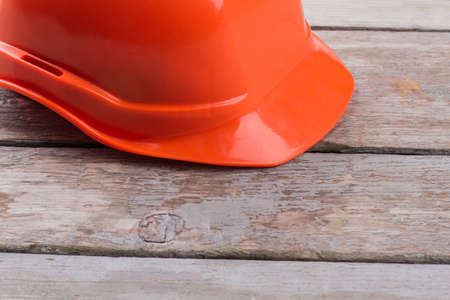 Orange worker's helmet on the old wooden table. Close up counstructor's cap.の写真素材