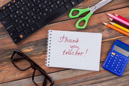 Thank you teacher! School accessories on brown wooden table.の写真素材