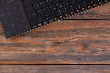 PC keyboard on a wooden table. Copy space, free space for text.